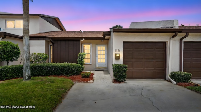 view of front of house with an attached garage, driveway, and stucco siding
