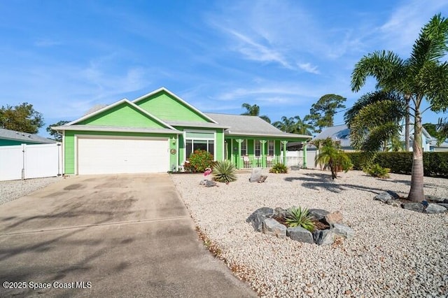6190 Alderwood Ave, Cocoa, FL 32927 - view of front facade featuring covered porch, fence, an attached garage, and driveway