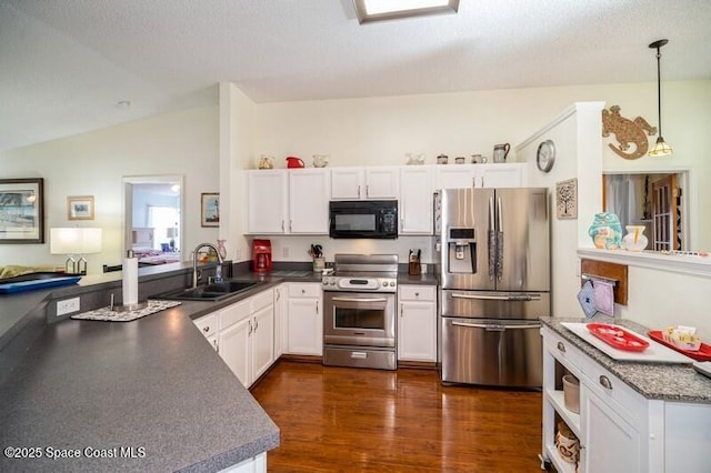 6190 Alderwood Ave, Cocoa, FL 32927 - kitchen featuring dark countertops, white cabinetry, a sink, vaulted ceiling, and stainless steel appliances