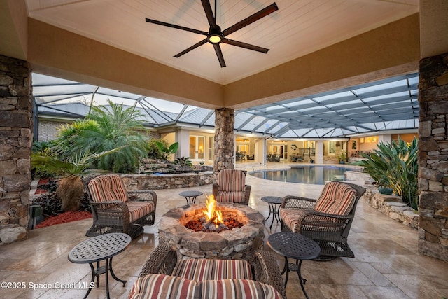 view of patio / terrace with ceiling fan, a fire pit, and an outdoor pool