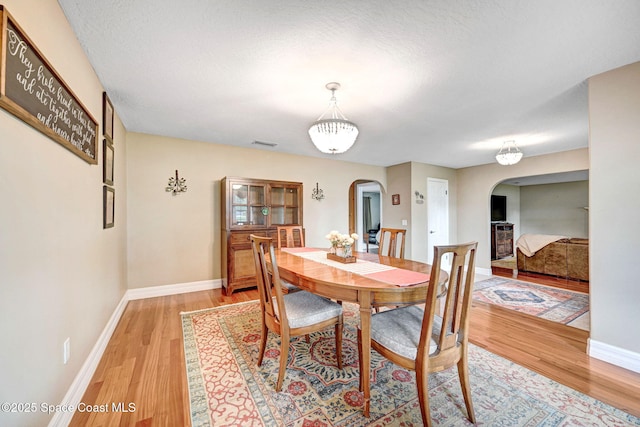 1428 Gleneagles Way, Rockledge, FL 32955 - dining area with arched walkways, light wood-style floors, visible vents, and baseboards