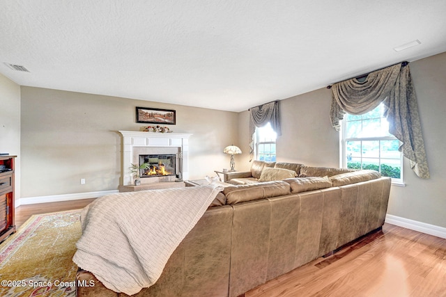 1428 Gleneagles Way, Rockledge, FL 32955 - living area featuring baseboards, light wood finished floors, a tiled fireplace, and visible vents