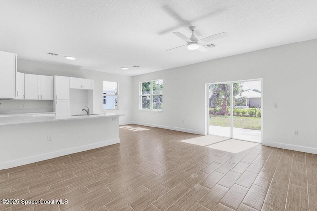 8050 96th Ave, Vero Beach, FL 32967 - unfurnished living room featuring light wood-style flooring, baseboards, recessed lighting, and a textured ceiling