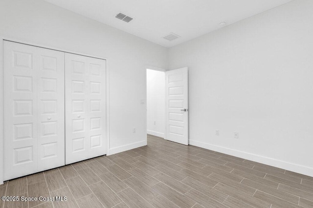 8050 96th Ave, Vero Beach, FL 32967 - unfurnished bedroom with wood finished floors, baseboards, and a closet