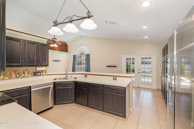 kitchen with lofted ceiling, light countertops, french doors, a sink, and appliances with stainless steel finishes