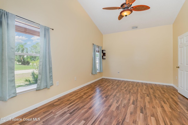 spare room featuring baseboards, a ceiling fan, vaulted ceiling, and wood finished floors