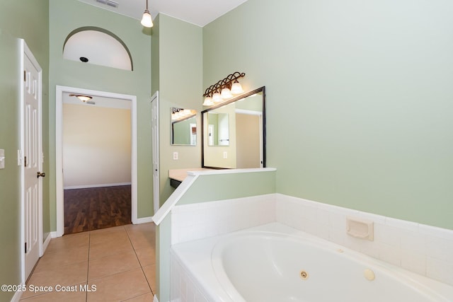 full bathroom featuring visible vents, vanity, a jetted tub, baseboards, and tile patterned floors