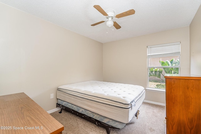 carpeted bedroom with baseboards, a ceiling fan, and a textured ceiling