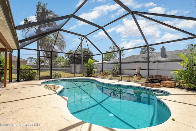 view of swimming pool featuring glass enclosure, a fenced in pool, a fenced backyard, and a patio area