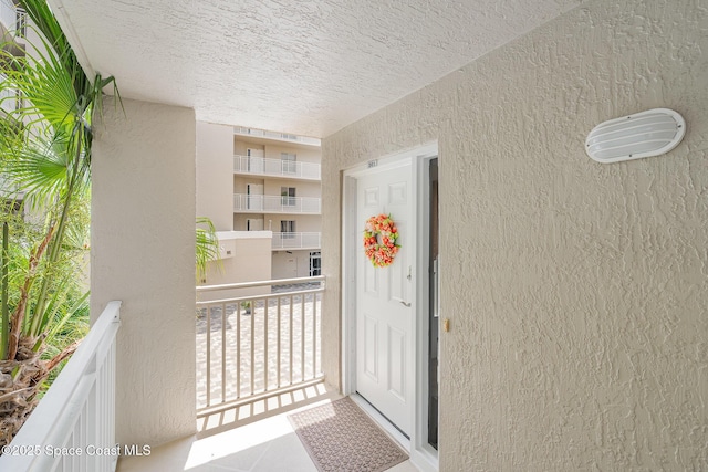 entrance to property with stucco siding and a balcony