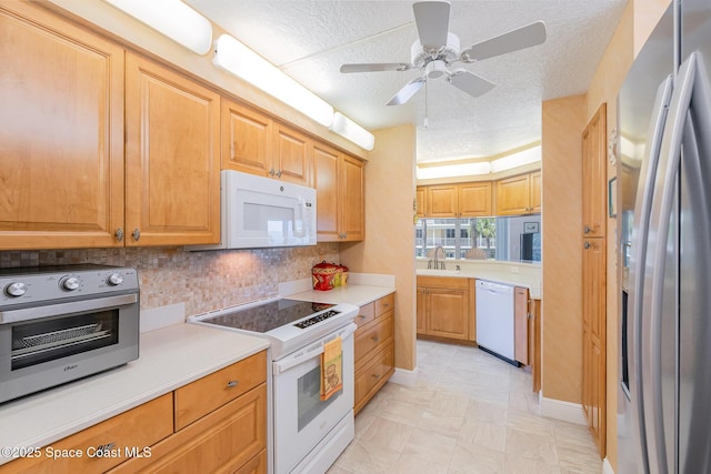 kitchen with white appliances, a toaster, a sink, and light countertops