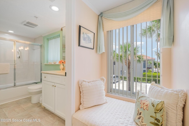 bathroom featuring vanity, crown molding, visible vents, toilet, and shower / bath combination with glass door