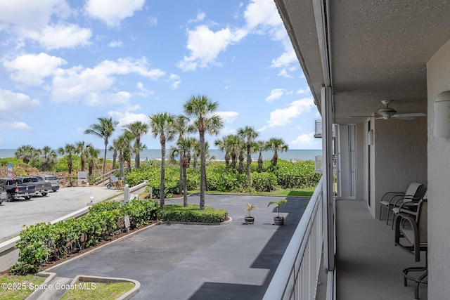 balcony with a water view and ceiling fan