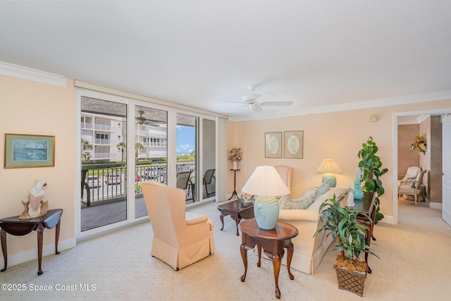carpeted living area featuring crown molding, a ceiling fan, and baseboards