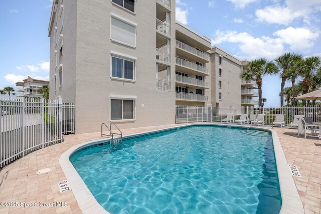 pool with fence and a patio area