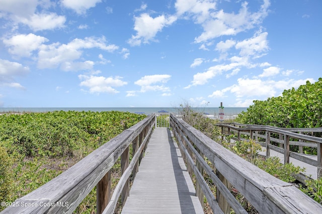 view of property's community with a water view and a view of the beach