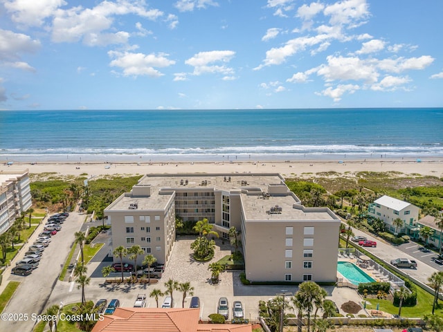 birds eye view of property with a water view and a beach view