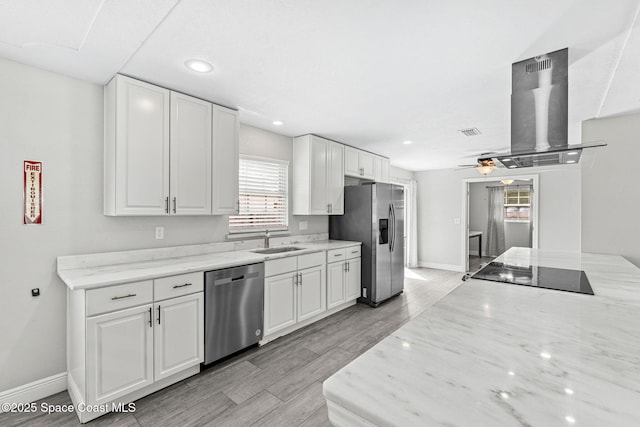 947 Bluewater Dr, Indian Harbour Beach, FL 32937 - kitchen with appliances with stainless steel finishes, island range hood, plenty of natural light, white cabinets, and recessed lighting