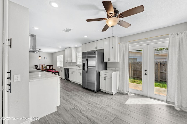 947 Bluewater Dr, Indian Harbour Beach, FL 32937 - kitchen with stainless steel refrigerator with ice dispenser, black dishwasher, wall chimney range hood, french doors, and white cabinets