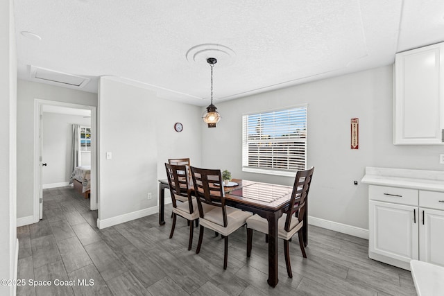 947 Bluewater Dr, Indian Harbour Beach, FL 32937 - dining space featuring light wood-type flooring, a textured ceiling, and attic access