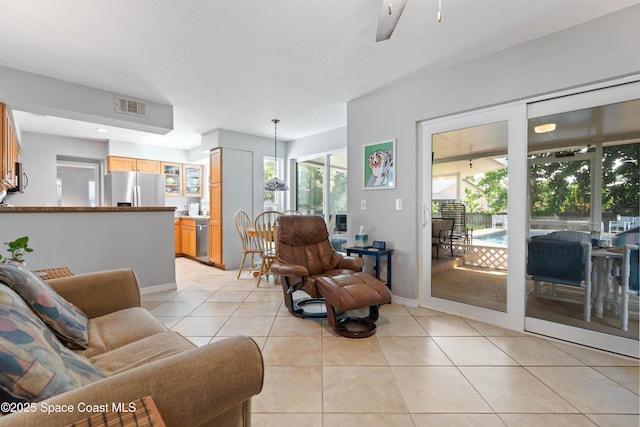 living room with visible vents, plenty of natural light, light tile patterned flooring, and ceiling fan