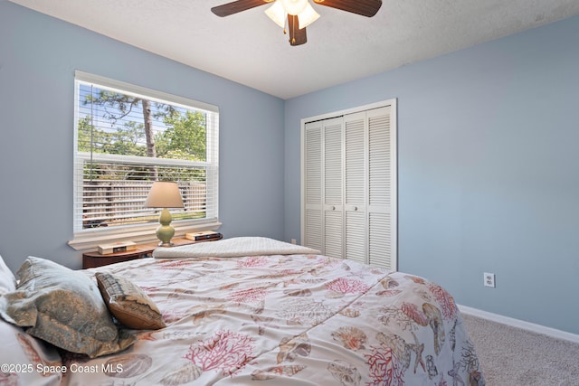 carpeted bedroom featuring baseboards, a ceiling fan, a closet, and a textured ceiling