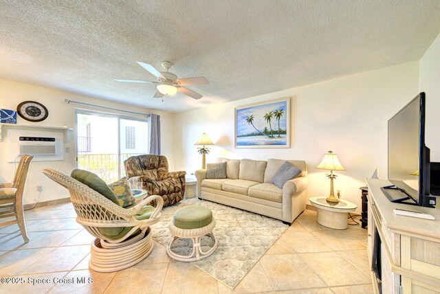 living room featuring an AC wall unit, a ceiling fan, a textured ceiling, and light tile patterned floors