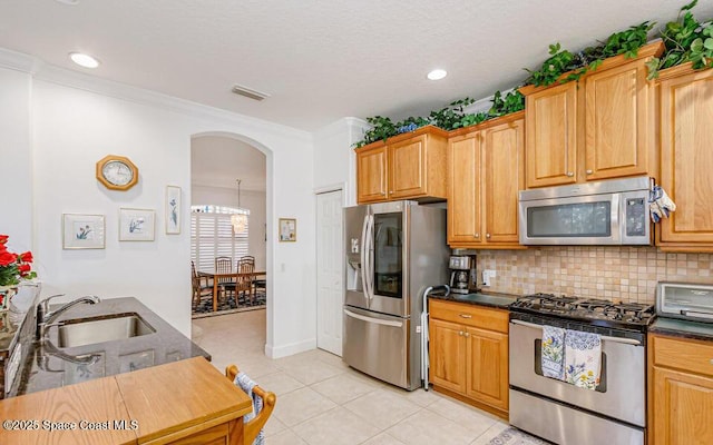 881 Glen Abbey Way, Melbourne, FL 32940 - kitchen featuring a sink, arched walkways, stainless steel appliances, light tile patterned floors, and backsplash