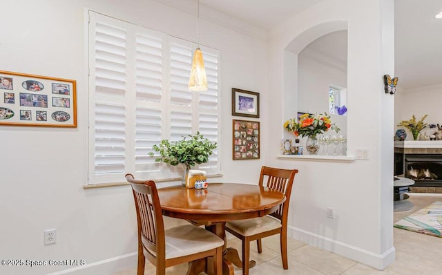 881 Glen Abbey Way, Melbourne, FL 32940 - dining area featuring arched walkways, baseboards, tile patterned flooring, and a fireplace