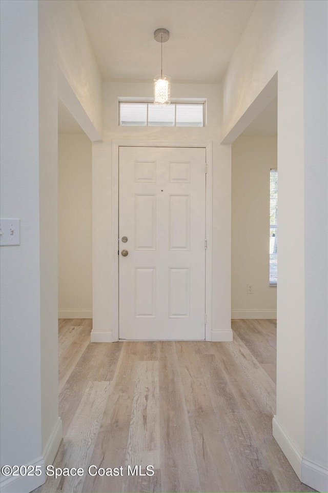 foyer with baseboards and light wood finished floors