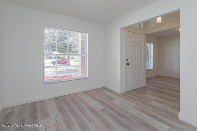 empty room featuring baseboards and wood finished floors