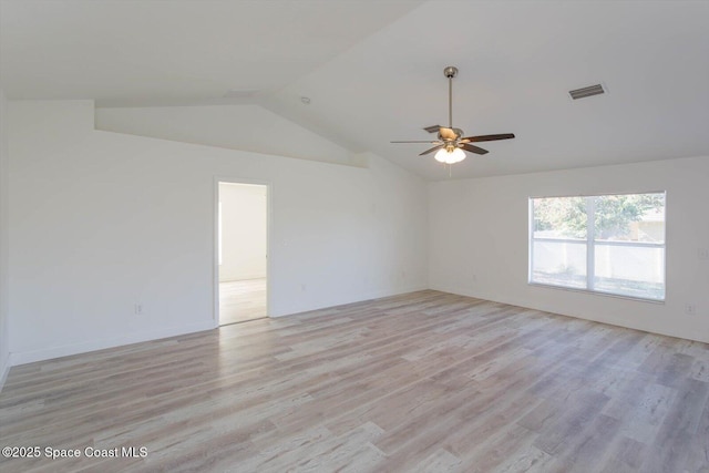 spare room with ceiling fan, visible vents, vaulted ceiling, and light wood-style floors