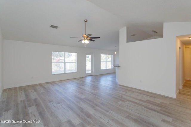 spare room featuring visible vents, baseboards, light wood-type flooring, a ceiling fan, and vaulted ceiling