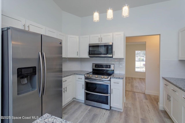 kitchen with light wood finished floors, appliances with stainless steel finishes, and white cabinetry