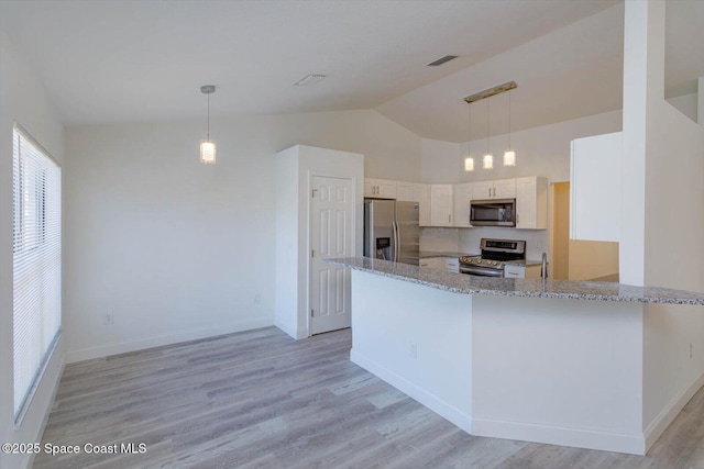 kitchen with light stone counters, light wood finished floors, appliances with stainless steel finishes, and lofted ceiling