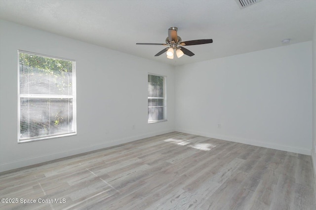 unfurnished room with a ceiling fan, baseboards, visible vents, and light wood finished floors