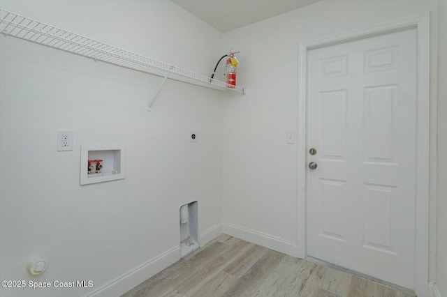 laundry area featuring laundry area, baseboards, hookup for a washing machine, electric dryer hookup, and light wood finished floors