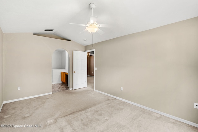 7416 Camio Ave, Cocoa, FL 32927 - unfurnished bedroom featuring light carpet, vaulted ceiling, baseboards, arched walkways, and ensuite bath