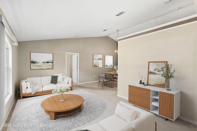 7416 Camio Ave, Cocoa, FL 32927 - living room with light carpet, lofted ceiling, baseboards, and healthy amount of natural light