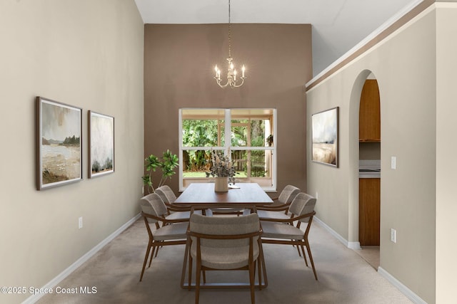7416 Camio Ave, Cocoa, FL 32927 - dining area featuring high vaulted ceiling, a chandelier, light colored carpet, arched walkways, and baseboards