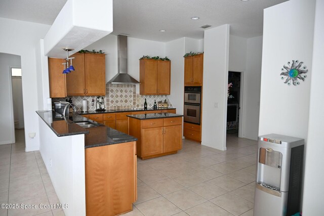 321 Brightwater Dr SE, Palm Bay, FL 32909 - kitchen with wall chimney range hood, double oven, brown cabinets, decorative backsplash, and recessed lighting