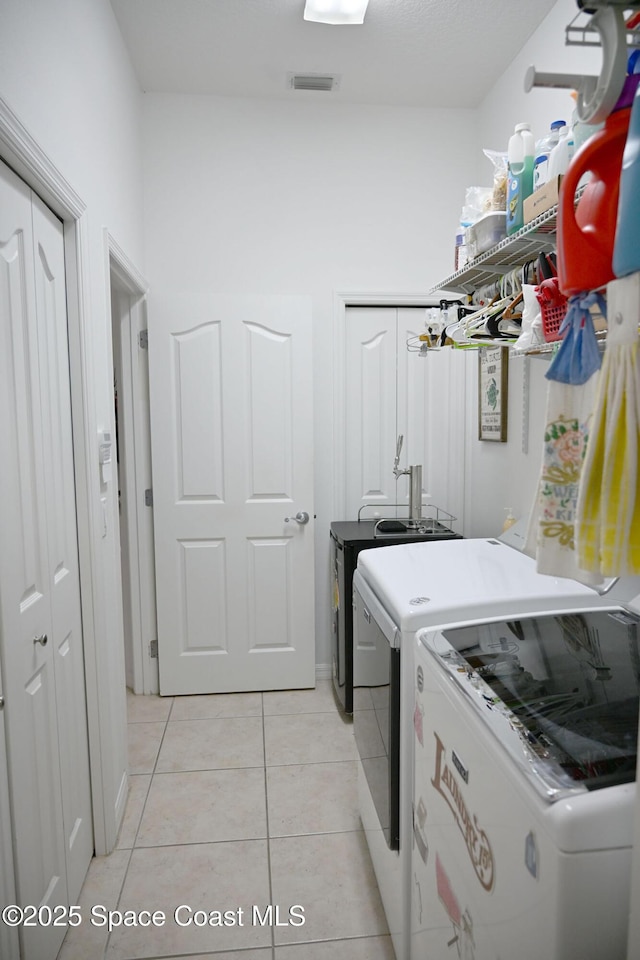 321 Brightwater Dr SE, Palm Bay, FL 32909 - washroom with washer and dryer and light tile patterned flooring