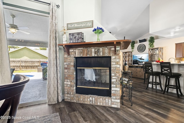 944 Osprey Ln, Rockledge, FL 32955 - living area with wood finished floors, a fireplace, ceiling fan, and vaulted ceiling