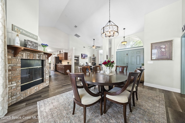 944 Osprey Ln, Rockledge, FL 32955 - dining room with a fireplace, ceiling fan, high vaulted ceiling, dark wood-style flooring, and a chandelier