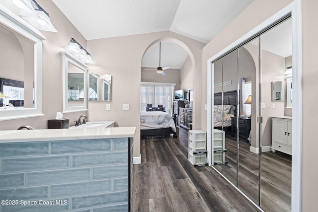 944 Osprey Ln, Rockledge, FL 32955 - ensuite bathroom with vaulted ceiling, wood finished floors, vanity, ceiling fan, and baseboards