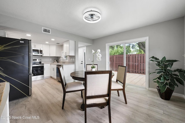 dining space with recessed lighting, baseboards, light wood-type flooring, and visible vents