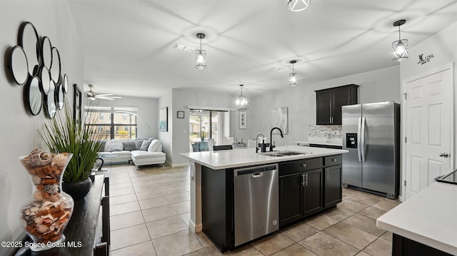 kitchen featuring appliances with stainless steel finishes, a sink, light countertops, and light tile patterned floors