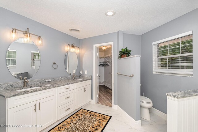 7703 Windover Way, Titusville, FL 32780 - bathroom featuring visible vents, a sink, marble finish floor, and a textured ceiling