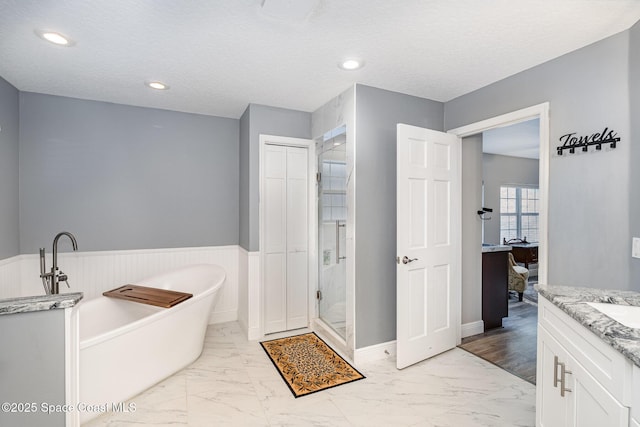 7703 Windover Way, Titusville, FL 32780 - bathroom with vanity, marble finish floor, a soaking tub, and a shower stall