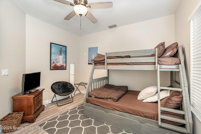 7703 Windover Way, Titusville, FL 32780 - bedroom featuring a textured ceiling, a ceiling fan, wood finished floors, and visible vents